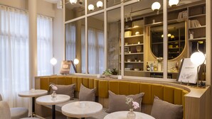 Ein modernes Interieur mit Sitzbereichen, runden Tischen und einer Spiegelwand.