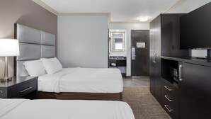 A hotel room with two beds, a desk, a TV, and a bathroom visible in the background. - Best Western Webster Hotel, Nasa (Webster)