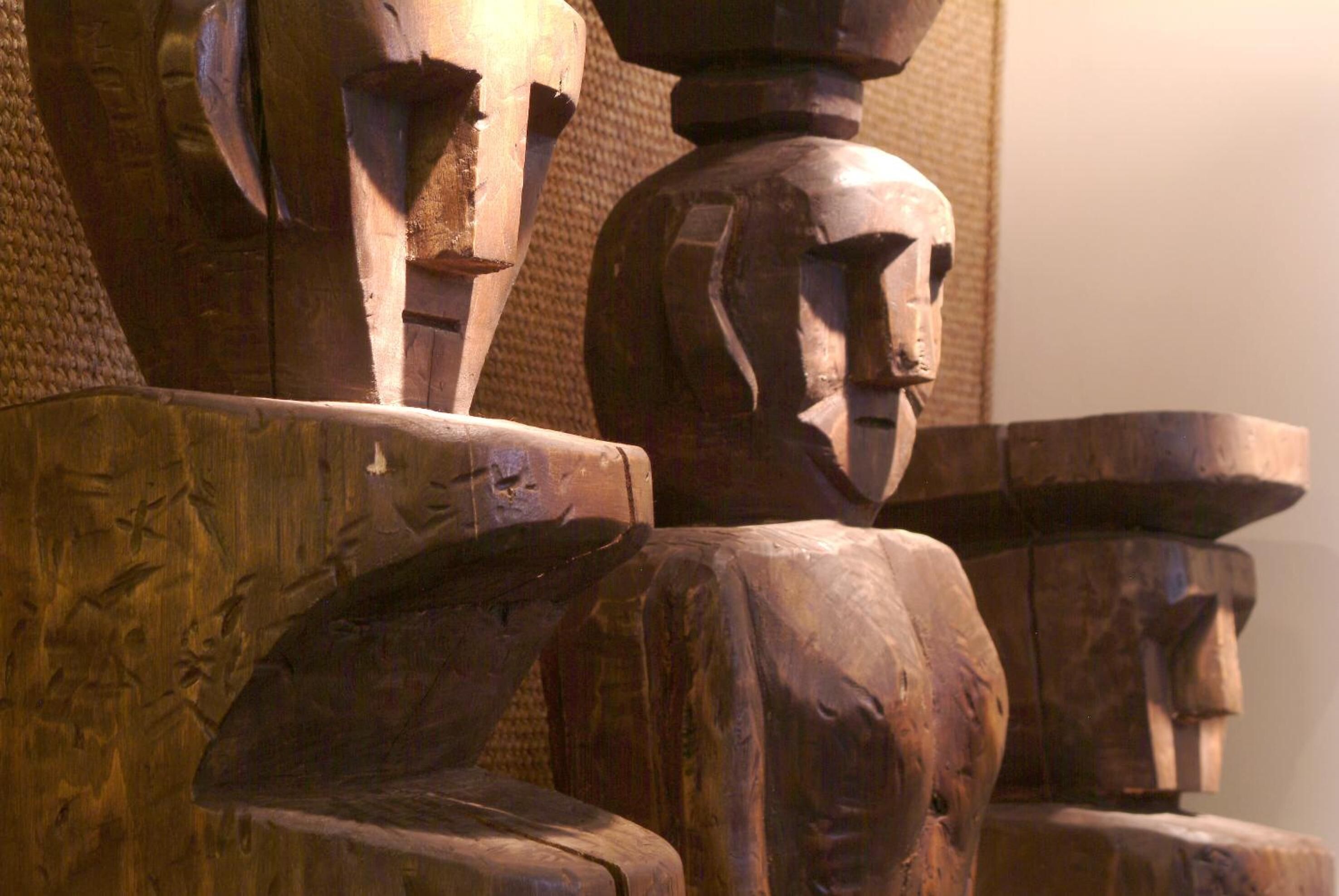 Una escultura de madera con figuras humanas abstractas.