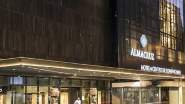Une façade d’hôtel moderne avec l’inscription « Almacruz » et le panneau « Hotel Centro de Conglomerados ».
