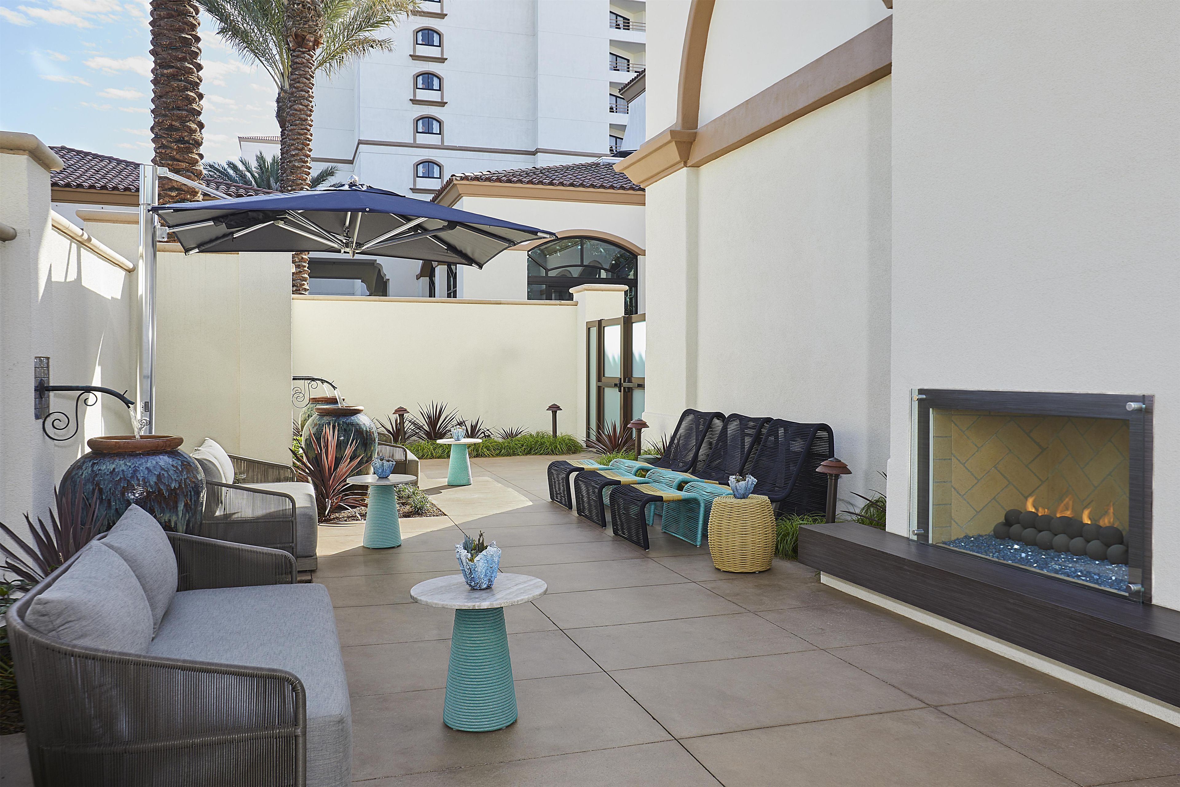 An outdoor patio with seating, a fire feature, and a large planter.