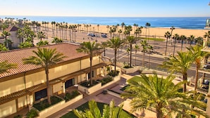 A hotel with a beach view, palm trees, and a parking lot. - The Waterfront Beach Resort, A Hilton Hotel (Huntington Beach)