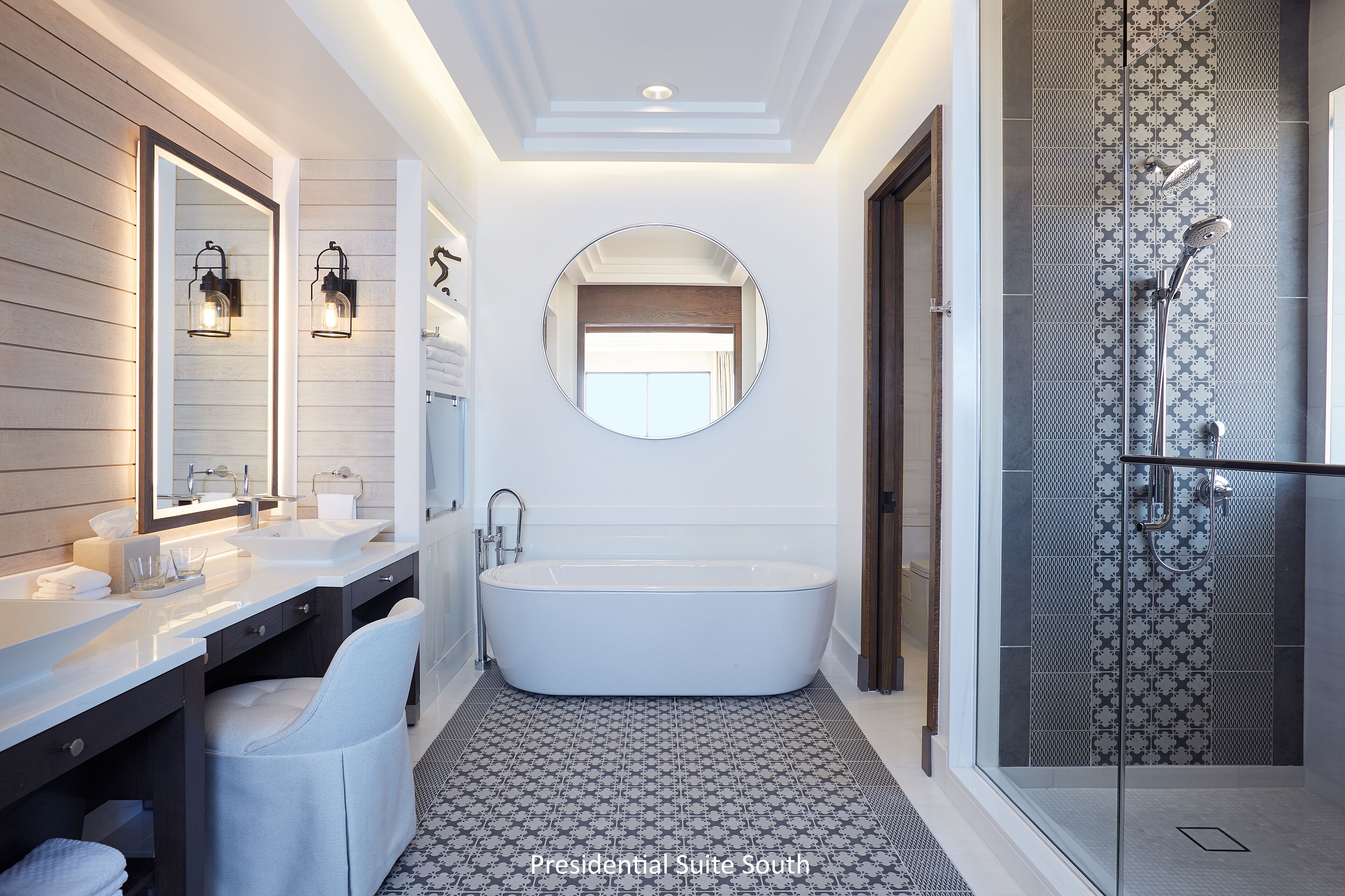 A modern bathroom with a freestanding bathtub, a glass-enclosed shower, and a vanity with two sinks.