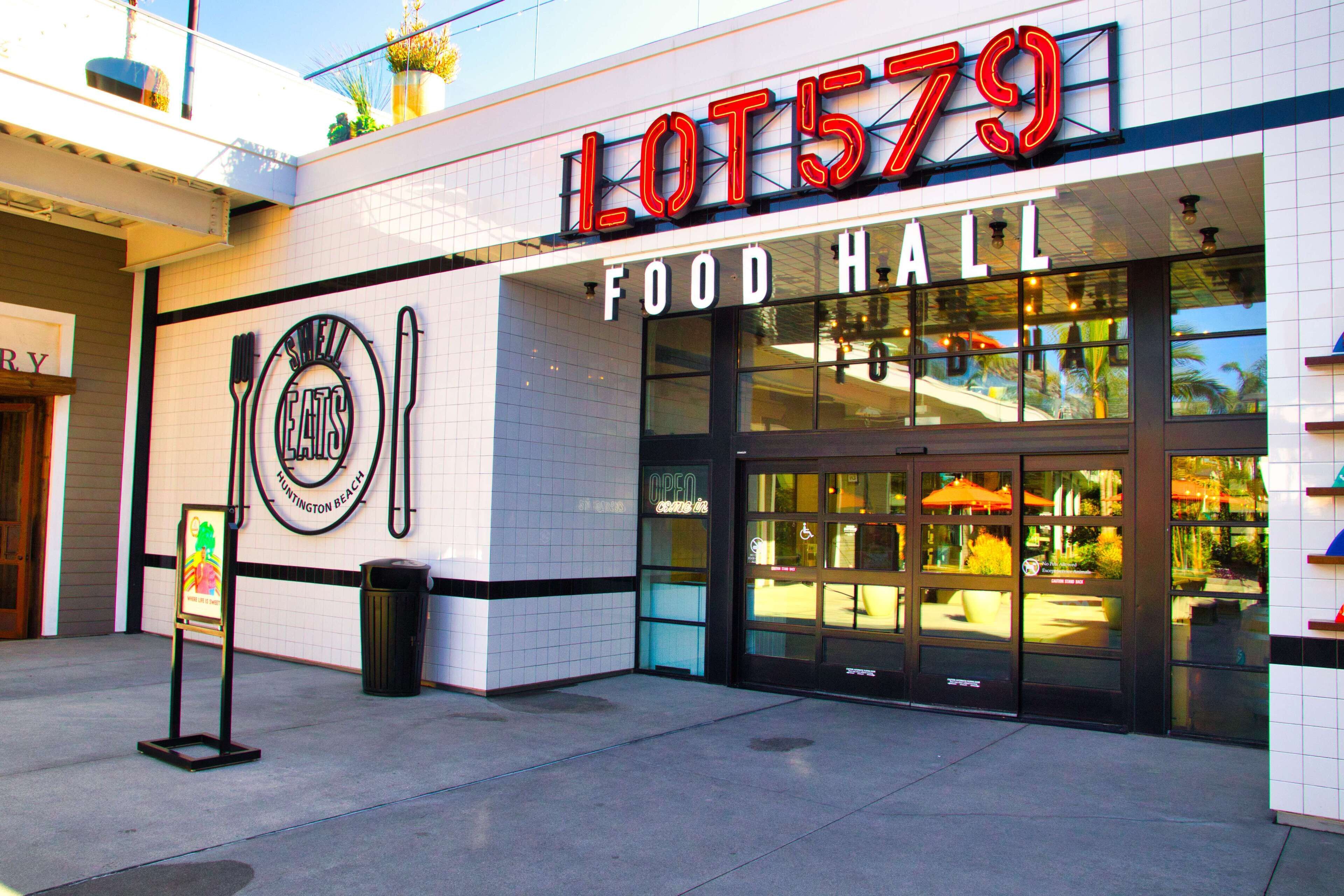 Un espacio gastronómico llamado "LOT 579" con un letrero que muestra un sombrero de chef y un tenedor y cuchillo.