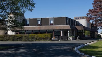 Un hotel moderno con techo plano, grandes ventanales y un cartel que indica que se trata de un hotel.