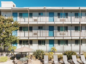 Una piscina al aire libre, sombrillas, sillones reclinables de piscina