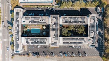 Una piscina al aire libre, sombrillas, sillones reclinables de piscina