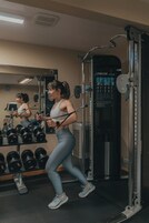 Un gimnasio con equipo de ejercicio y mancuernas.