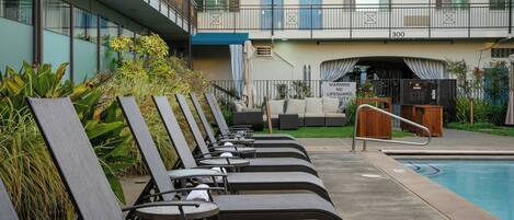 A poolside area with lounge chairs and a pool.