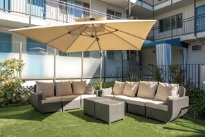 Una piscina al aire libre, sombrillas, sillones reclinables de piscina