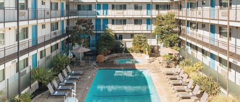 Alberca al aire libre, sombrillas en la alberca y camastros