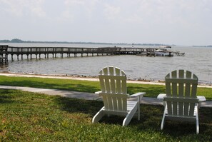 Relax in serene lakeside tranquility with Adirondack chairs and a wooden pier.