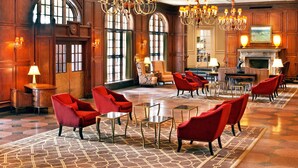 A spacious lobby with red armchairs, chandeliers, and a fireplace. - Hotel Roanoke & Conference Ctr, Curio Collection by Hilton  (Roanoke)