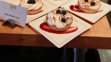 Uma variedade de tartes de limão e merengue dispostas sobre uma mesa de madeira.