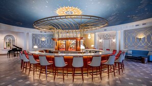 A bar area with a central circular bar, multiple seating options, and a ceiling with a starry design. - Hotel Roanoke & Conference Ctr, Curio Collection by Hilton  (Roanoke)