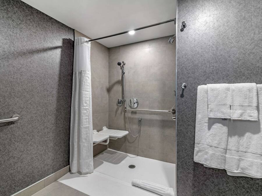 A modern bathroom with a shower, a toilet, and a towel rack.