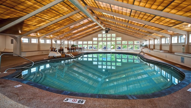 Una piscina interior con techos altos y ventanas amplias.