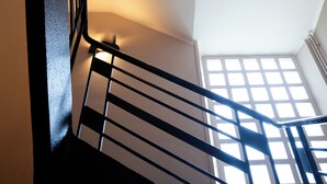 A staircase with a black railing and a window at the top.