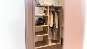 A walk-in closet with shelves, a hanging rod, and a radio.