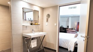 A modern bathroom with a white sink, mirror, and towel rack.