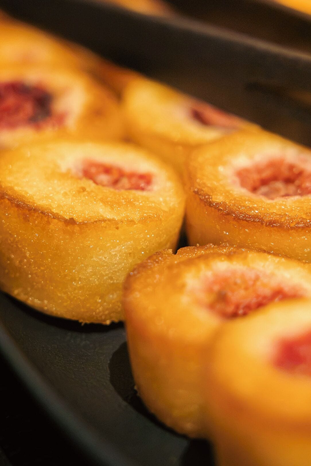 Primer plano de un producto horneado con corteza dorada, posiblemente un pastel o pan, con un relleno visible.