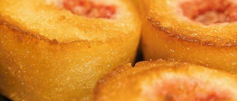 A close-up of a baked item with a golden-brown crust, possibly a pastry or bread, with a visible filling.