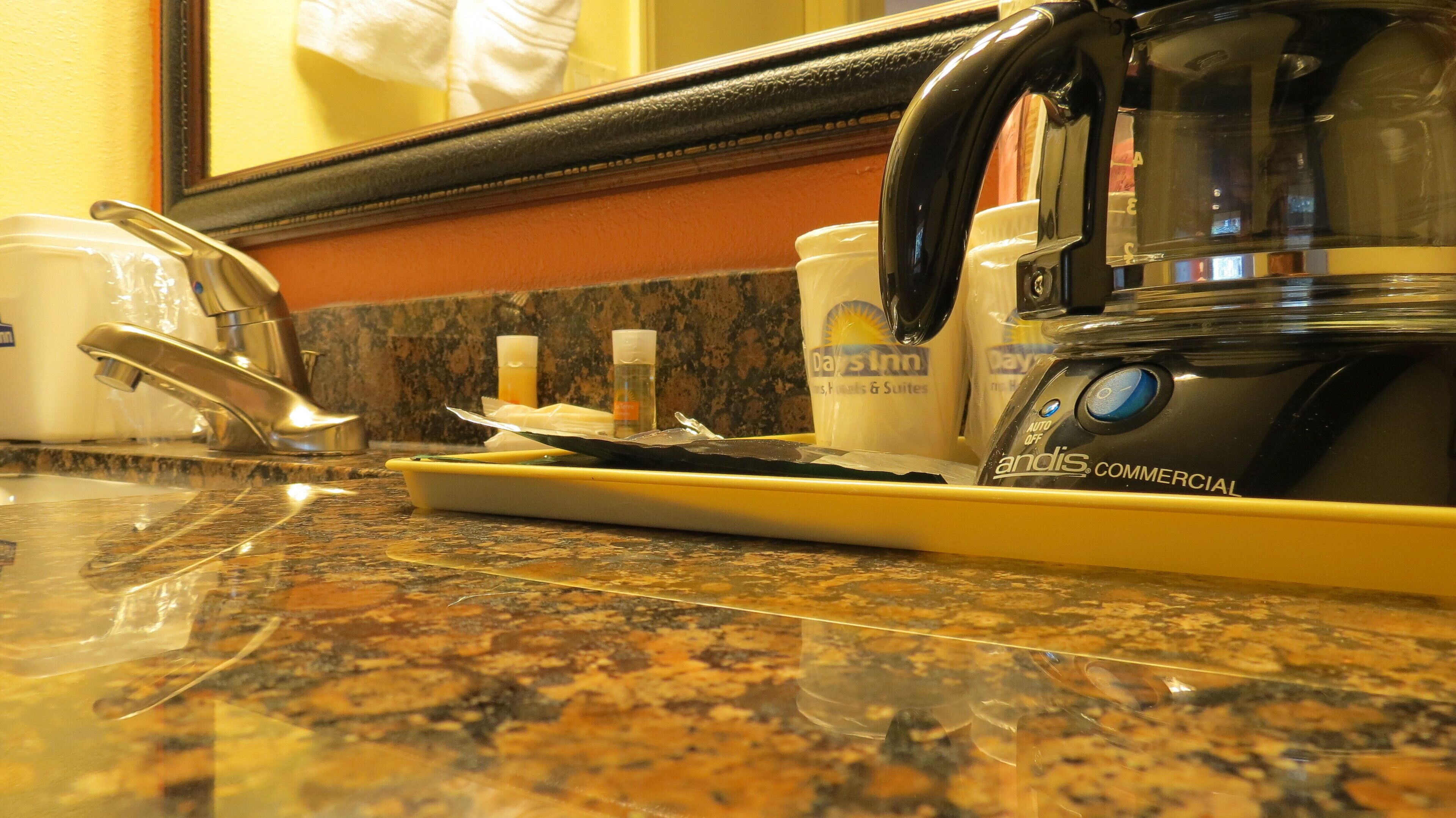 A kitchen counter with a coffee maker, a toaster, and a cup of coffee.