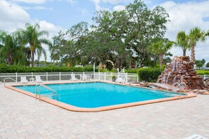 Relax by the pool surrounded by lush greenery and a tranquil waterfall.