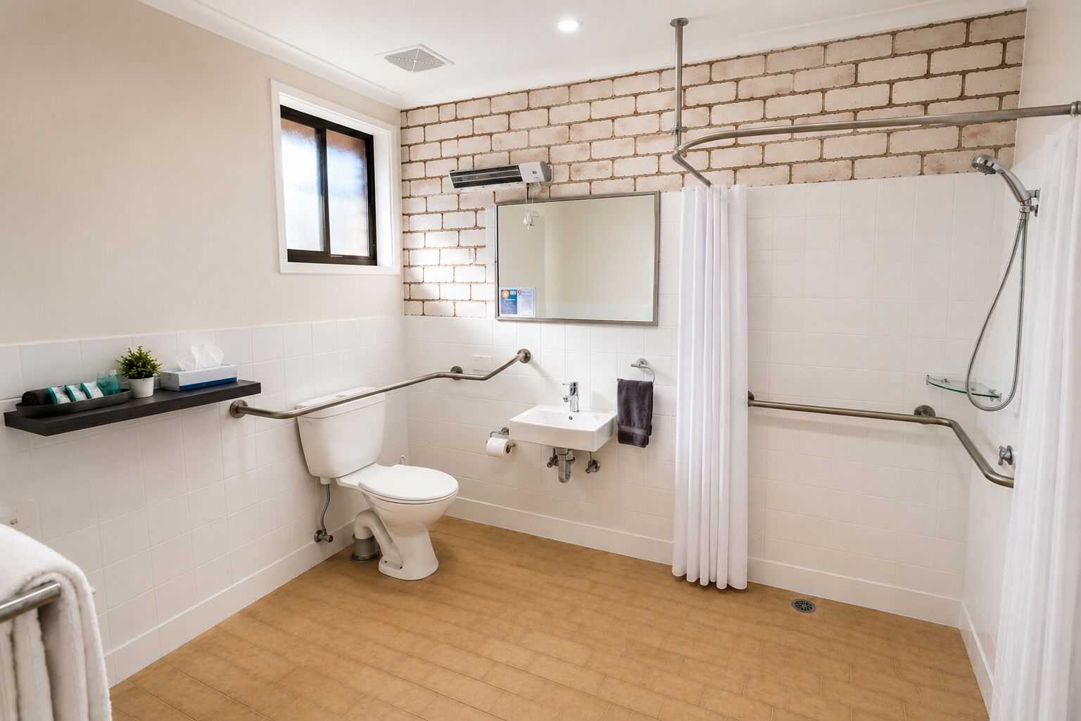 A bathroom with a white toilet, a sink, a mirror, a shower with a glass door, and a window.