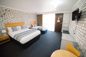 Relax in this stylish room with a large bed, a smaller bed, and a desk area.