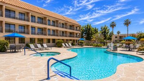 A hotel with a swimming pool, lounge chairs, and umbrellas. - Holiday Inn Express Palm-Desert by IHG (Palm Desert)