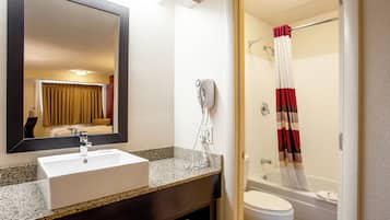 Une salle de bain avec un lavabo, un miroir et une douche.