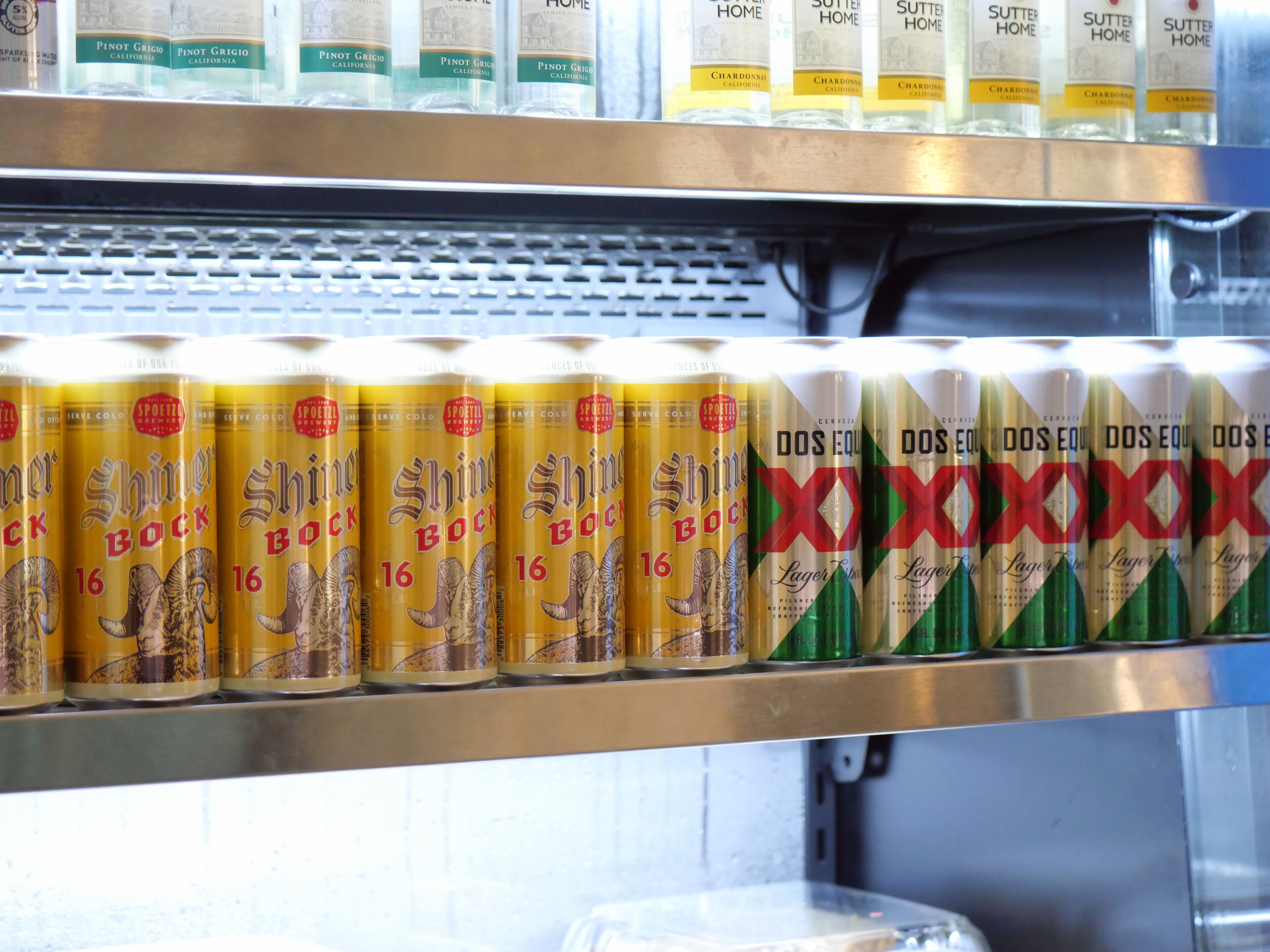 Mostra refrigerada de diverses marques de cervesa, incloent 'Shiner Bock' i 'XXOXXOXX'.