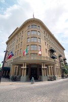 A historic building with a curved facade, multiple windows, and a central entrance.
