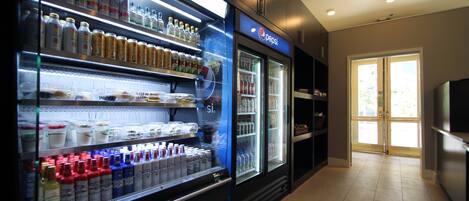 A refrigerated display case with various beverages and a Pepsi refrigerator in a commercial setting.