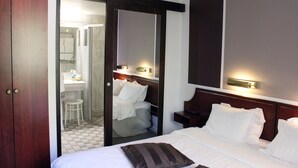 A hotel room with a bed, a nightstand, a mirror, and a wooden wardrobe. - Hotel Djingis Khan (Lund)