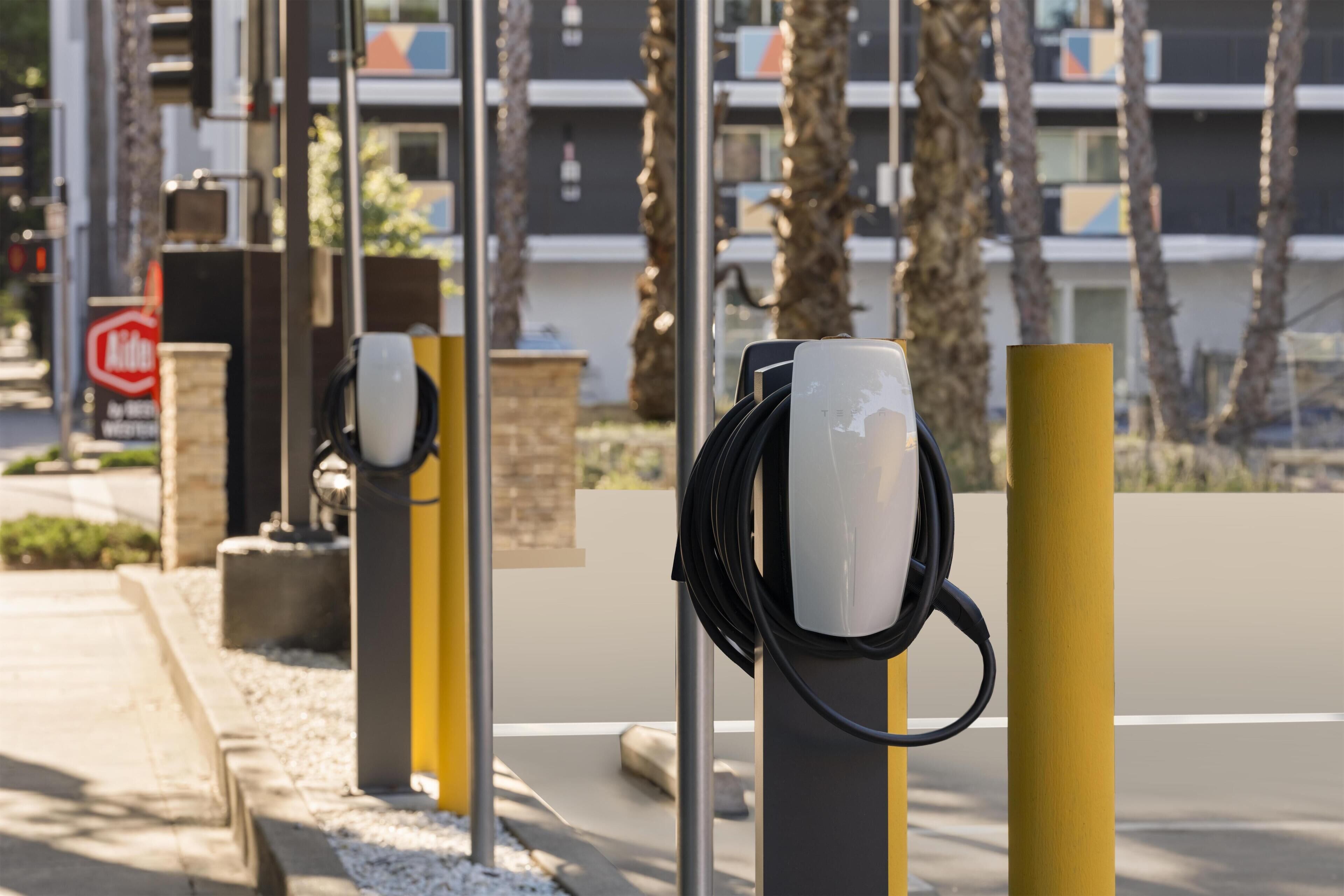 Electric vehicle charging stations with a building in the background.
