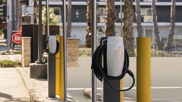Electric vehicle charging stations with a building in the background.