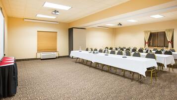 A conference room with a long table, chairs, a projector, and a whiteboard.