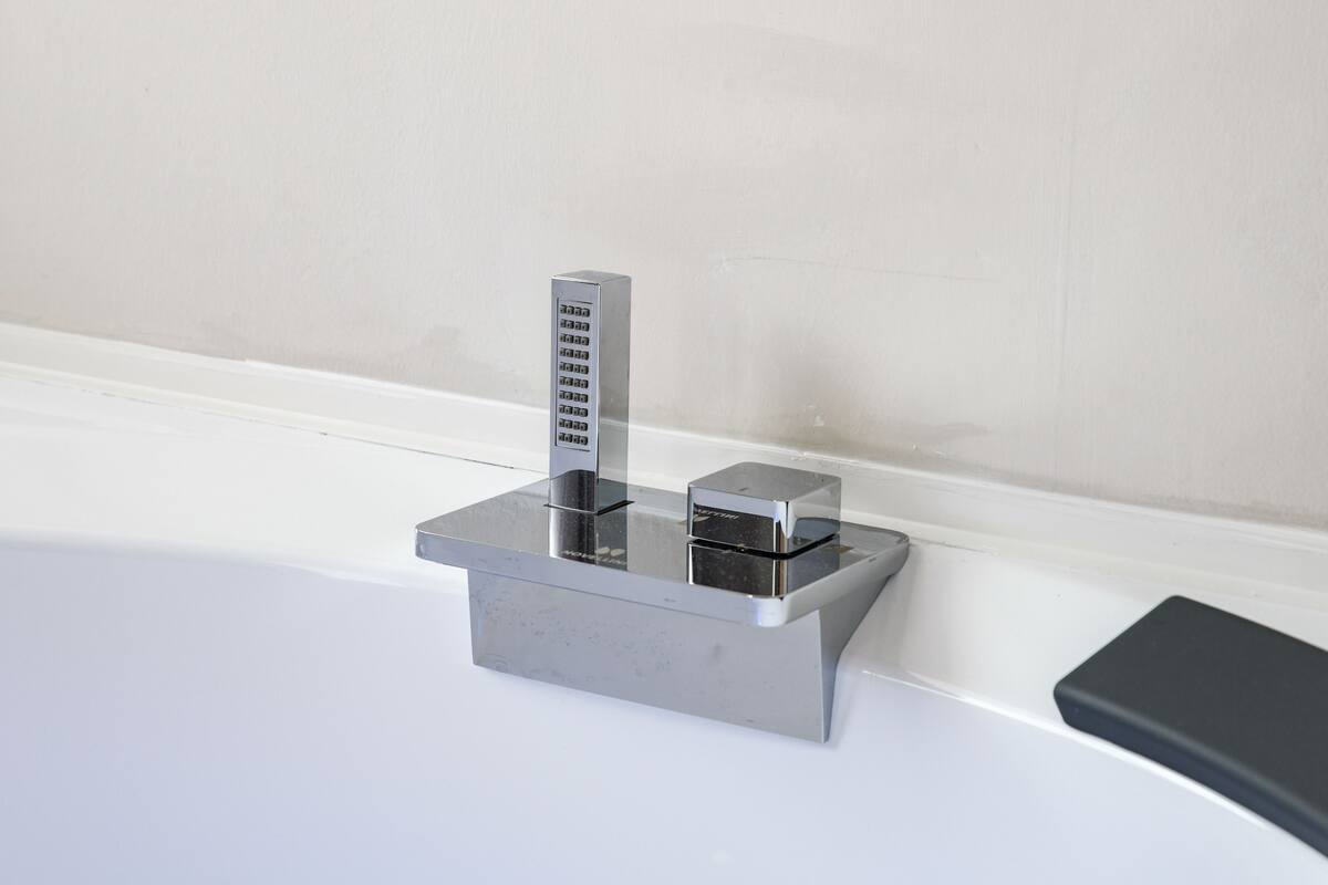 A modern bathroom with a chrome faucet and a rectangular sink.