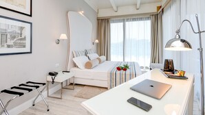 Una habitación de hotel moderna con cama, escritorio y una computadora portátil.