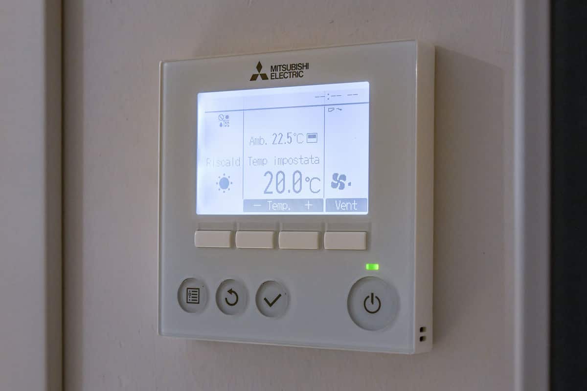 A Mitsubishi Electric thermostat with a digital display, temperature settings, and control buttons.
