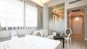 Un baño moderno con una bañera grande, un sofá y una silla.