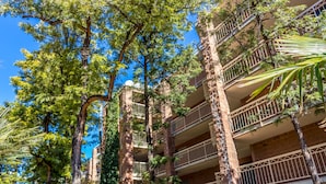 A multi-story building with balconies and trees.