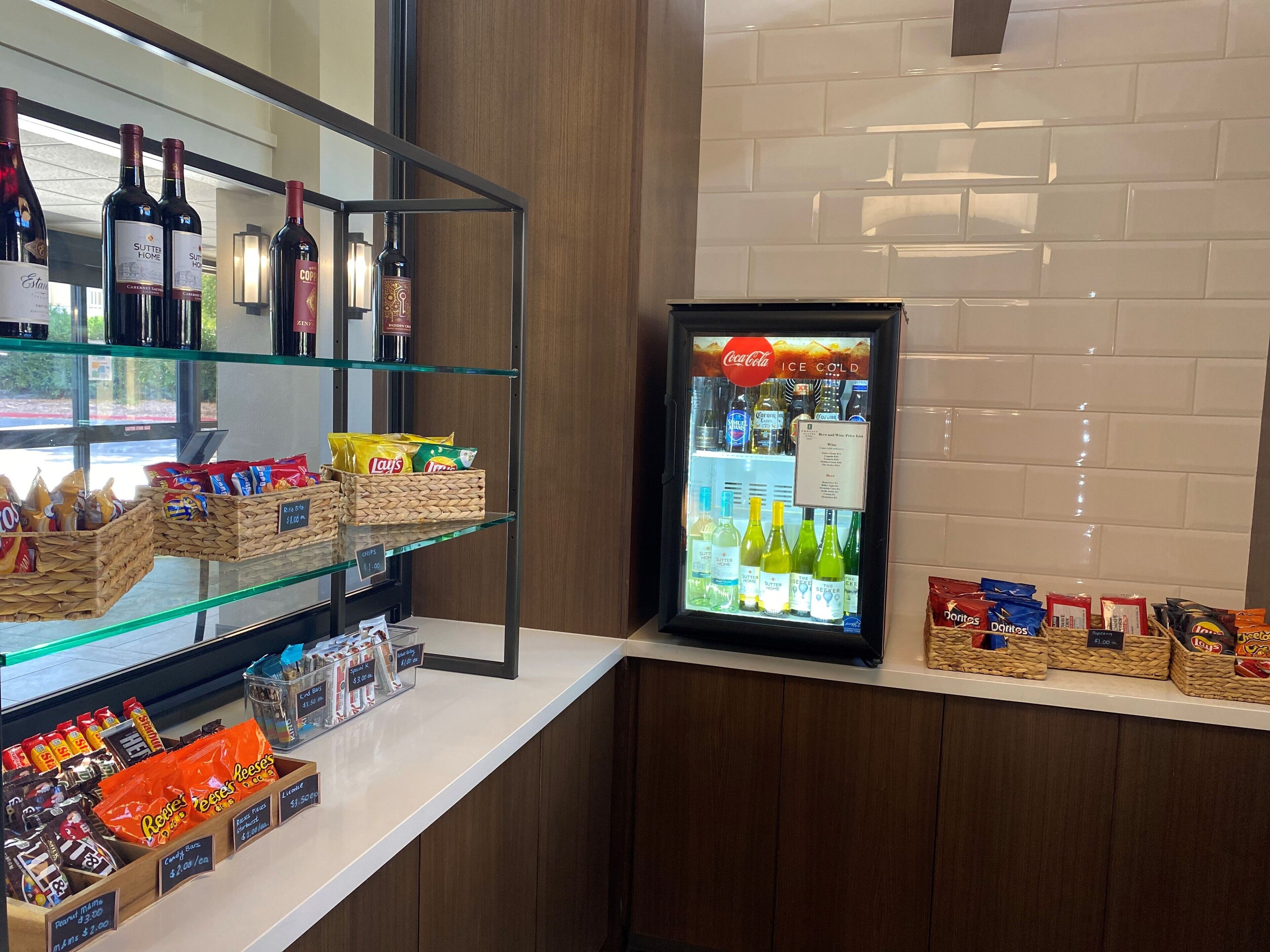 A snack bar with various snacks and drinks, including chips, candies, and bottled water.