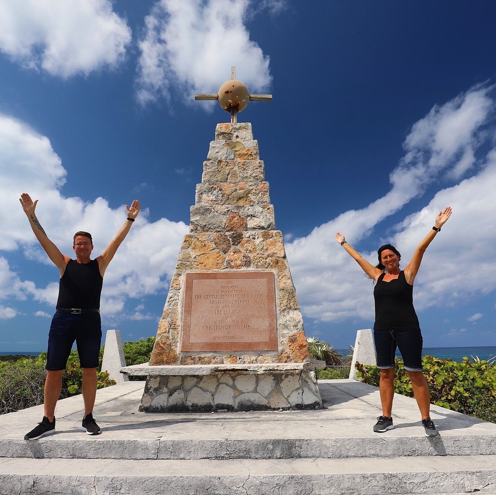A stone monument with a plaque dedicated to the Lucayan people and Christopher Columbus, featuring a spherical object on top.