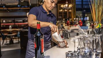 A bartender pouring a drink into a glass.