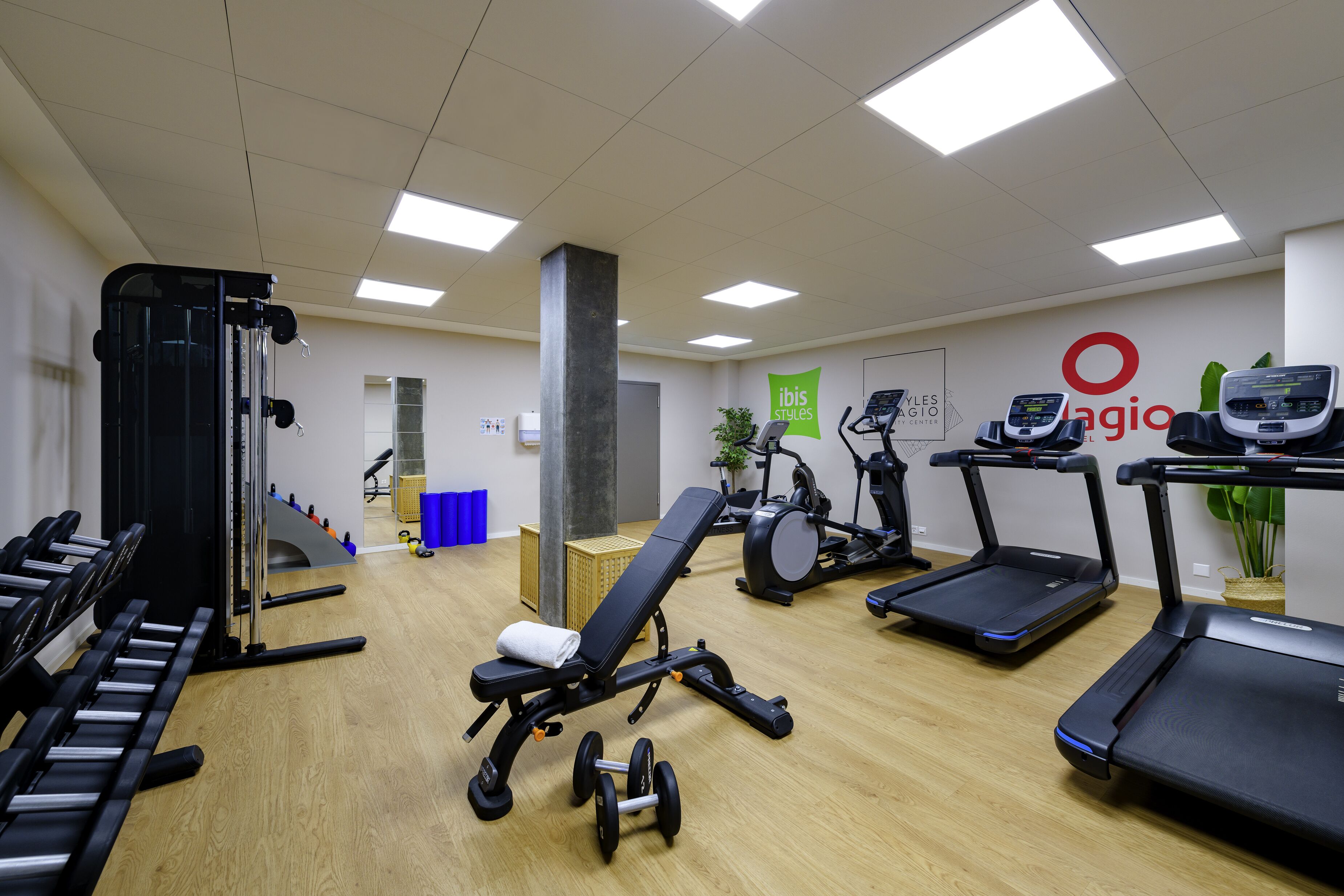 A gym with exercise equipment, including treadmills, a bench, and weights.