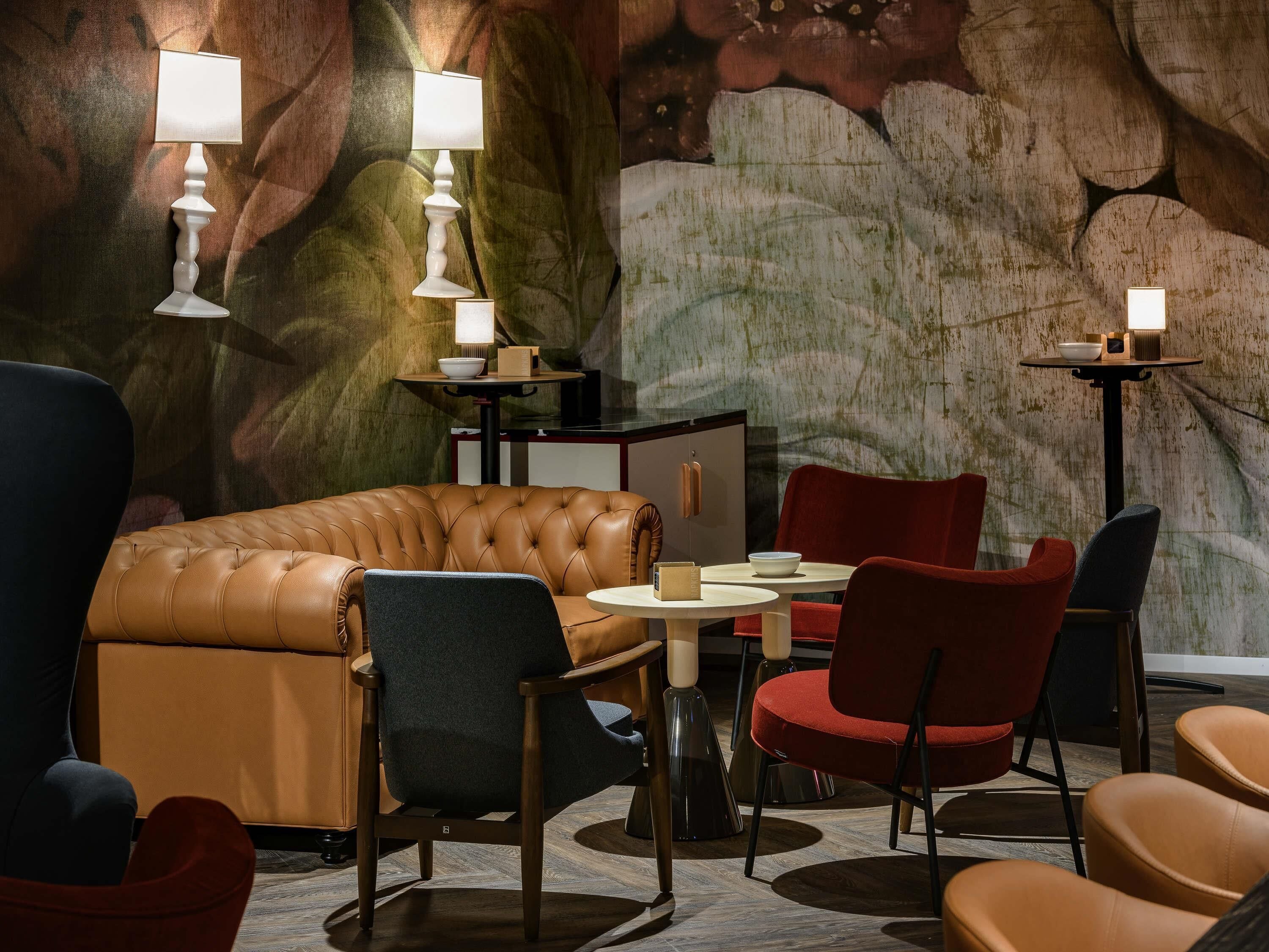 A modern lounge area with leather seating, a round table, and ambient lighting.