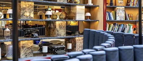 A hotel lobby with marble shelves, seating areas, and a variety of decorative items.